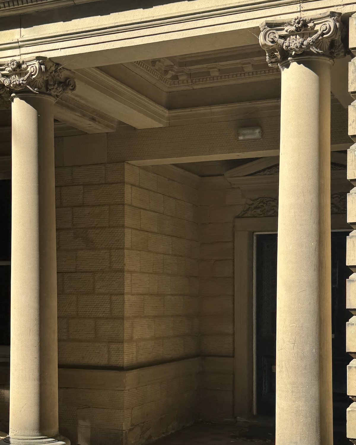 Stone columns with carved capitals supporting a porch.