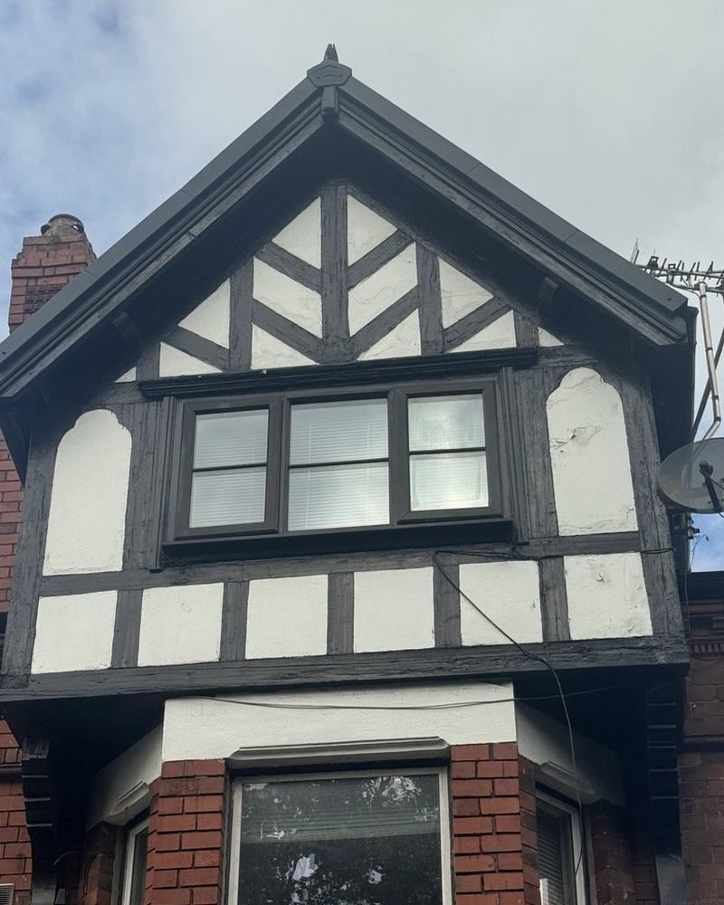 A black and white timbered gable above red brick.